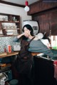 A woman standing in a kitchen next to a sink.