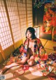 A woman in a kimono sitting on the floor.