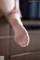 A close up of a woman's feet in white stockings.