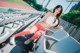 A woman in a white top and red leggings sitting on a stadium bench.