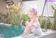 A woman sitting on the edge of a swimming pool.