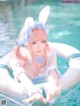 A woman in a bunny costume is floating in a pool.