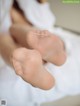 A close up of a person's bare feet on a bed.