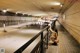 A naked woman sitting on a bench in a subway station.