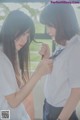 A woman in a white shirt is helping another woman put on her tie.