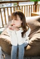 a woman sitting on top of a couch next to a window