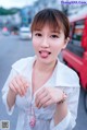 A woman sticking out her tongue in the middle of the street.