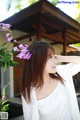 A woman in a white shirt is posing for a picture.