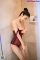 A woman in a red lingerie is taking a shower.