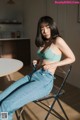 A woman sitting on a chair in a kitchen.