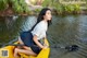 A woman sitting in a yellow canoe on a river.