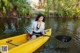 A woman in a yellow kayak paddling down a river.