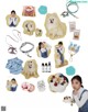 A woman holding a white dog in front of a bunch of items.