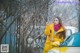 A woman in a yellow coat standing next to a yellow car.