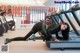 A woman laying on a treadmill in a gym.