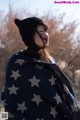 A woman wrapped in a blanket with stars on it.