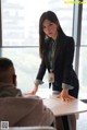 A woman in a business suit sitting at a table.