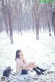 A woman sitting on the ground in the snow.