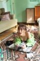 A woman laying on the floor playing a video game.