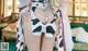 A woman in a cow print dress is posing for the camera.