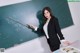 A woman in a business suit standing in front of a blackboard.