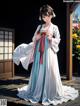 A woman in a white and blue dress standing on a wooden deck.