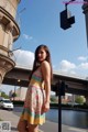 A woman standing in front of a traffic light.