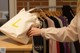 A woman holding a white bag with the letter L on it.