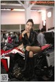 A woman sitting on top of a red and white motorcycle.