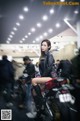 A woman sitting on top of a red motorcycle.