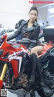 A woman sitting on top of a red motorcycle.