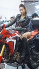 A woman sitting on top of a red motorcycle.