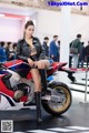 A woman sitting on top of a red and white motorcycle.